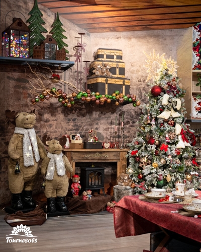 Décoration de Noël rustique avec ours en peluche et sapin décoré.